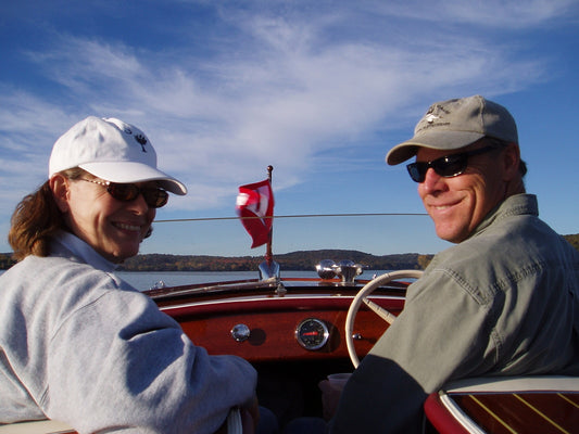 Man and Woman driving a restored wooden boat